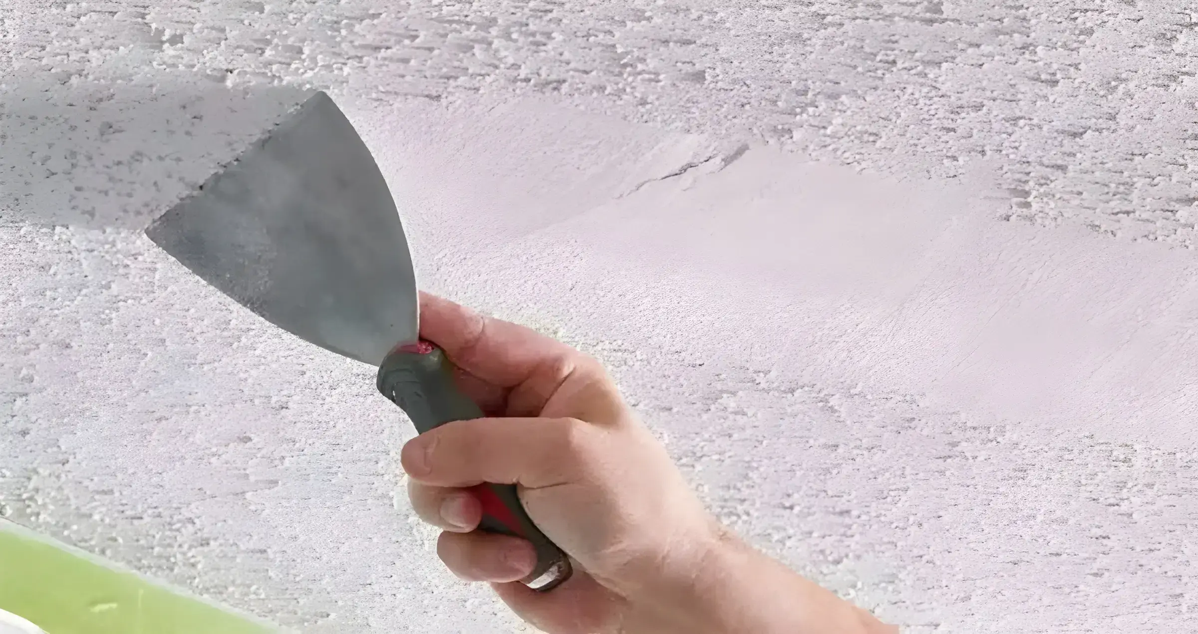 Los Pintores Valladolid eliminando el gotelé con espátula para dejar la pared lisa